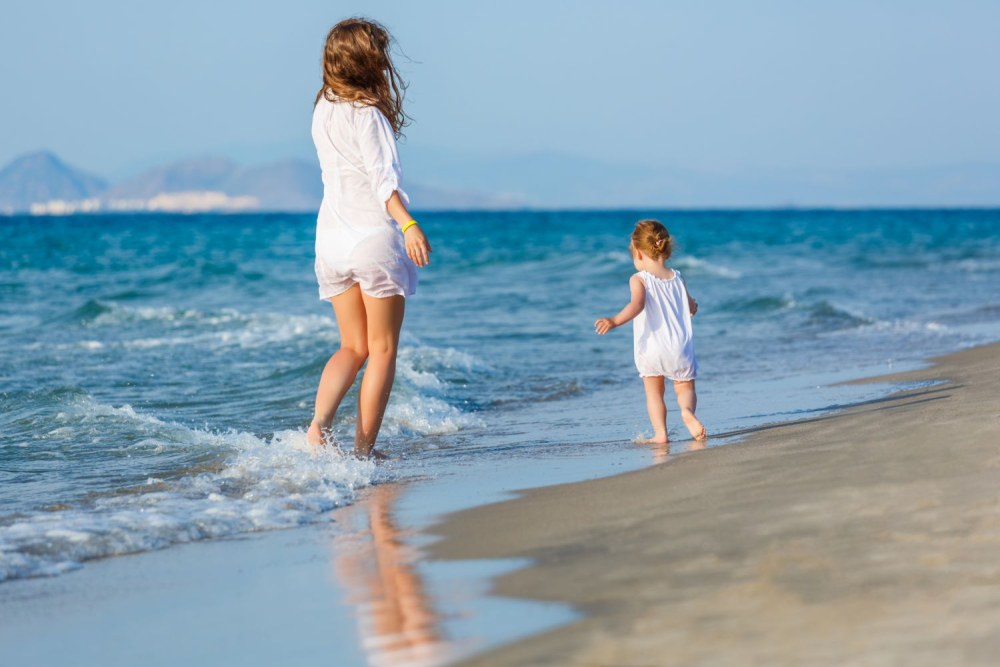 Maman et fille s'embrassent sur la plage