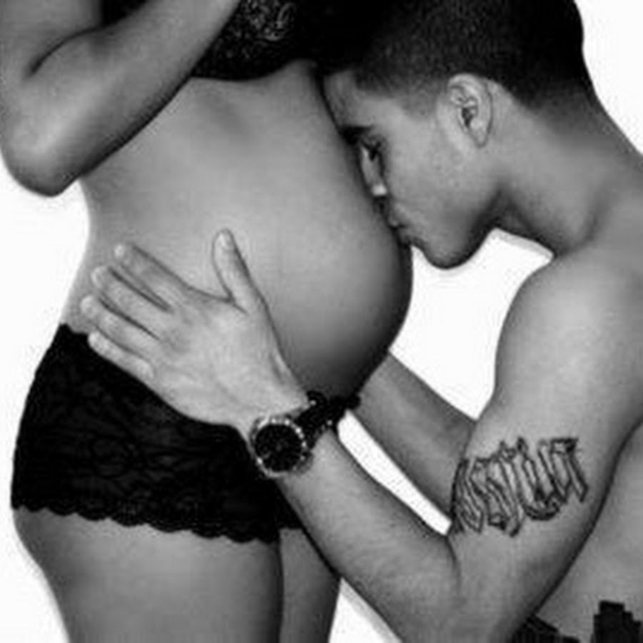 Le gars embrasse l'estomac de la femme enceinte